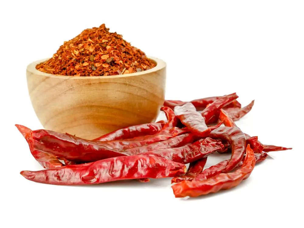 Pile crushed red pepper, Cayenne pepper, dried chili flakes isolated on white background